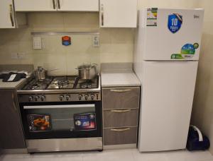 مساكن كيو في الدمام: مطبخ مع موقد وثلاجة