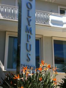 a sign on a building with flowers in front of it at Olympus Resort in Alba Adriatica