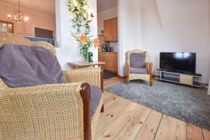 a living room with two chairs and a flat screen tv at Villa Magdalena 05 in Ahlbeck