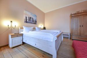 a bedroom with a large white bed and a wooden floor at Villa Magdalena 05 in Ahlbeck