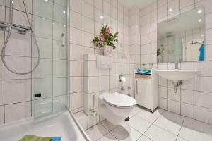 a white bathroom with a toilet and a sink at Villa Magdalena 05 in Ahlbeck +5 photos