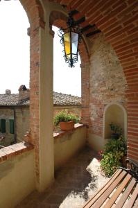 a porch with a bench and a light on a building at Palazzo Bizzarri in Rapolano Terme