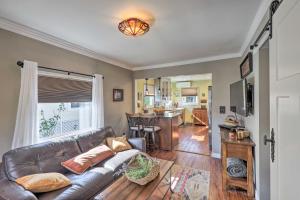 sala de estar con sofá de cuero y cocina en Charming Craftsman Cottage with Garden and Hot Tub! en Fullerton