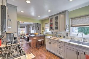 a kitchen with a sink and a stove top oven at Charming Craftsman Cottage with Garden and Hot Tub! in Fullerton