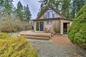 una casa con terraza y una casa en Coastal Cabin with Puget Sound and Rainier Views!, en Allyn