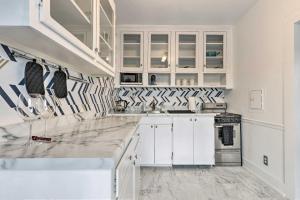 een keuken met witte kasten en marmeren aanrechtbladen bij Stunning Alabama Studio about 2 Mi to Dtwn Mobile! in Mobile
