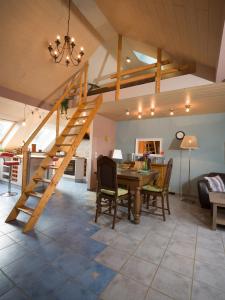 een woonkamer met een houten trap en een tafel en stoelen bij Ferienwohnung Maxima in Weiskirchen