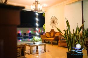 The Ocean Pearl Hotel Negombo في نيجومبو: غرفة معيشة مع أريكة وطاولة