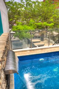 a swimming pool with a water fountain at Casa de Leda, a Kali Hotel in Santa Marta