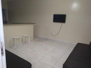 a room with two stools and a television on the wall at Linda casa novinha in Mongaguá
