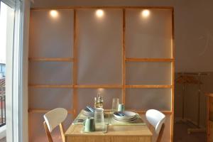 a dining room with a table and white chairs at Luxurious Japandi Loft in Ptolemaida