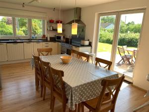 a kitchen and dining room with a table and chairs at Pen Braint in Newborough