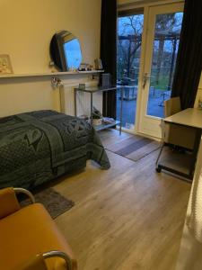 a bedroom with a bed and a sliding glass door at B&B 't Pakhuis in Meteren