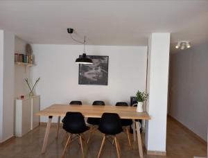 ein Esszimmer mit einem Holztisch und schwarzen Stühlen in der Unterkunft Modern house with 2 bedrooms near the beach in Castillo del Romeral