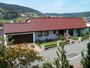 una casa con techo rojo y aparcamiento en Pension Haus Wanninger, en Warmensteinach