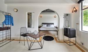 a room with a bed and a table and chairs at Minimalist One Hauz Khas Village in New Delhi