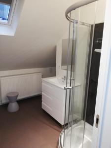 uma casa de banho branca com um chuveiro e um lavatório. em NUVOLA Summer Spring em Zottegem