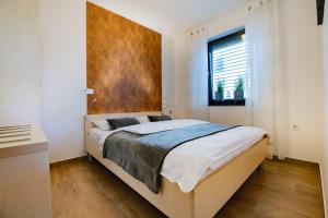Schlafzimmer mit einem Bett mit einem Kopfteil aus Holz in der Unterkunft Apartmaji BANONIA " Sončni zahod " in Banovci
