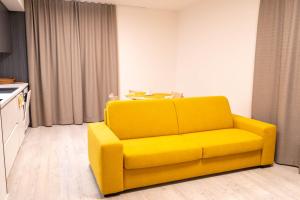 a yellow couch in a living room with a table at Hillside Y34 in Dolný Kubín