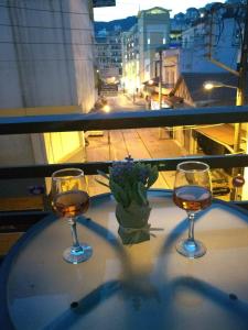 a table with two glasses of wine and a plant at Kavala's central apartment in Kavála