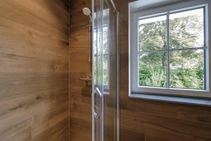 uma cabina de duche em vidro numa casa de banho com uma janela em Apartments in the countryside near Brussels em Lasne