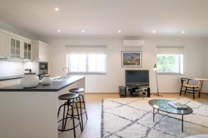 a kitchen and living room with a table and a tv at Apartments in the countryside near Brussels in Lasne