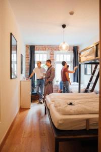 een groep mensen die in een kamer met bedden staan bij Hostel Multitude in Leipzig
