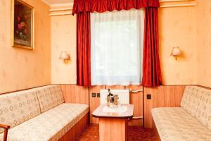 Beatrix Hotel في بودابست: غرفة بسريرين ونافذة ذات ستائر حمراء