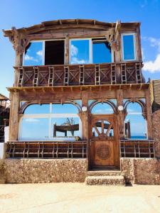 a building with a wooden door and a balcony at Villa Kon Tiki with private beach in Dahab