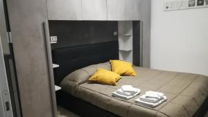 - un lit avec des oreillers et des serviettes jaunes dans l'établissement Miriamare, à Albissola Marina