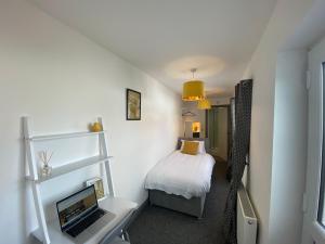 a small bedroom with a laptop computer on a desk at Silver Stag Properties, 4 BR Property in Newhall