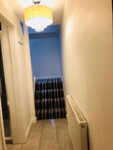 a hallway with a stairway with a black stair case at The Attic Suite Selsey in Selsey
