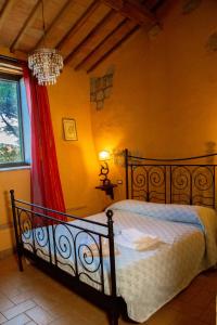 a bedroom with a bed and a window and a chandelier at Agriturismo Le Roghete in Acquapendente
