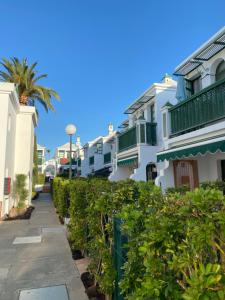 a row of apartment buildings with a palm tree at Bungalow Dunaflor Verde 4 in San Bartolomé