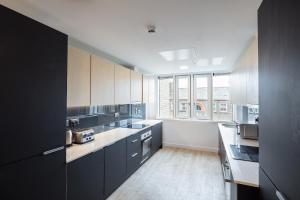 a kitchen with black cabinets and a large window at Destiny Student - Dominick Place in Dublin