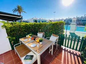 a table and chairs on a patio with a view of a pool at Bungalow Dunaflor Verde 4 in San Bartolomé