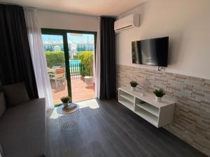 a living room with a flat screen tv on a wall at Bungalow Dunaflor Verde 4 in San Bartolomé