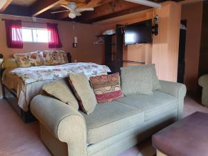 a bedroom with a bed and a couch and a tv at The Apt @Hacienda Rancho Santini in Rosarito
