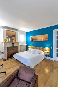 ein Schlafzimmer mit einem großen Bett und einer blauen Wand in der Unterkunft Gîte de la Plage in Étretat