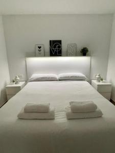 1 dormitorio con 1 cama blanca y 2 almohadas en La Vida es Bella Córdoba, en Córdoba