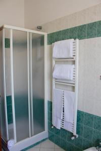 W łazience znajduje się prysznic i białe ręczniki. w obiekcie Agriturismo Vecchio Imposto w mieście Massa Marittima