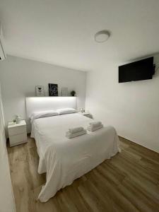 1 dormitorio blanco con 1 cama y TV de pantalla plana en La Vida es Bella Córdoba, en Córdoba