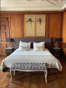 a bedroom with a large bed with a bench at Palacio Ramalhete in Lisbon +92 photos