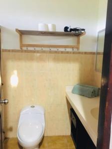 a bathroom with a white toilet and a sink at Drift Away Lodge in Playa Avellana