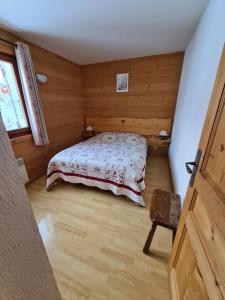 a bedroom with a bed in a wooden room at Apartment Residence Les Alpages in La Giettaz