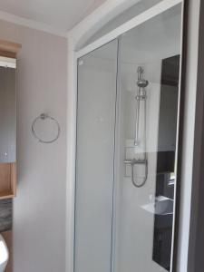 a bathroom with a glass shower with a mirror at 1 The Brambles in Cleethorpes