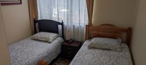 1 dormitorio con 2 camas y ventana en Hotel Andino Real, en Bogotá