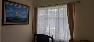 ein Fenster mit einem Vorhang und einem Bild eines Schiffes in der Unterkunft Hotel Andino Real in Bogotá