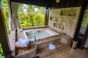 Una bañera en un baño con una ventana grande. en Hotel Lomas del Volcan, en Fortuna