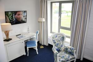 
a living room with a chair and a tv at Hotel Alter Kornspeicher in Neustrelitz
